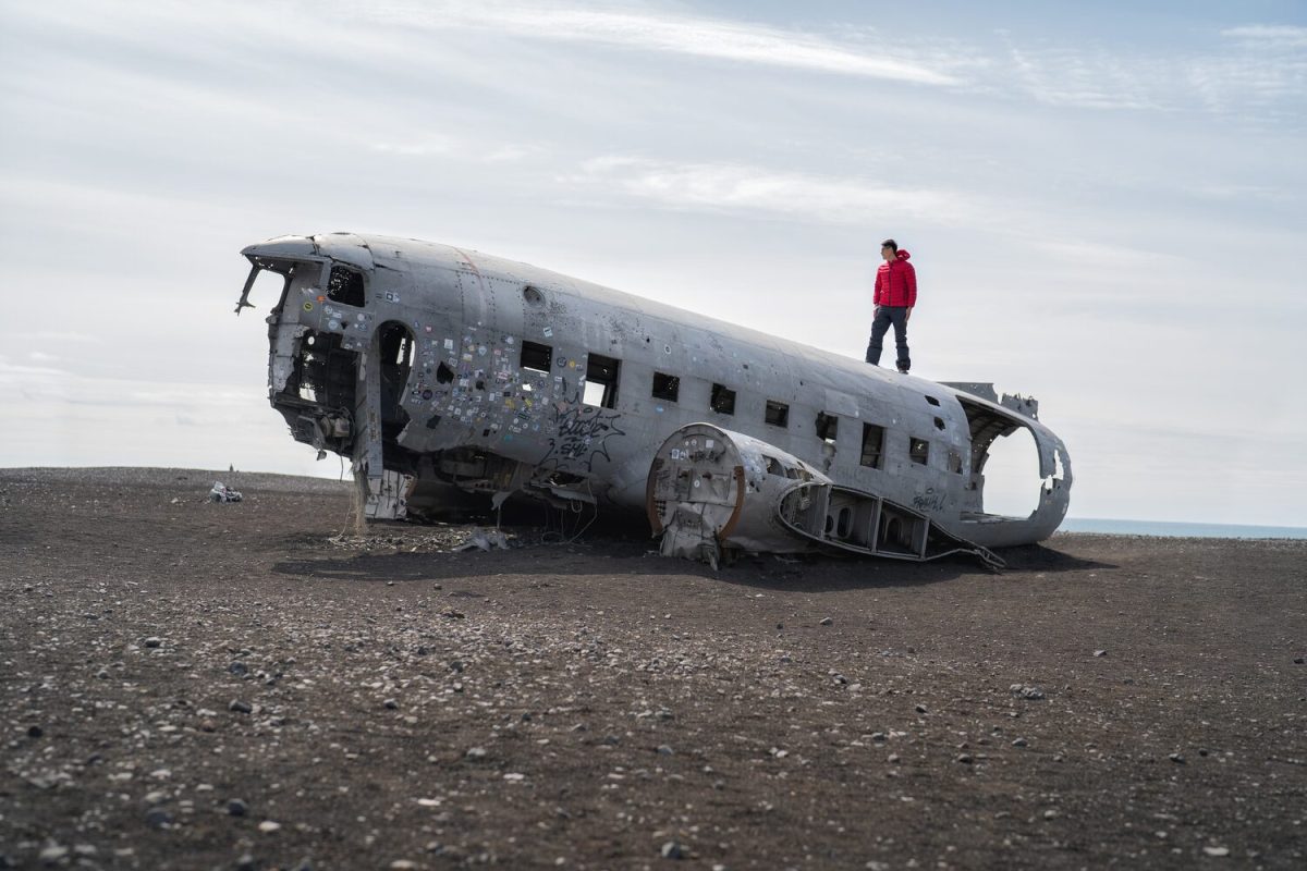 A tourist man standing on the plane wreck